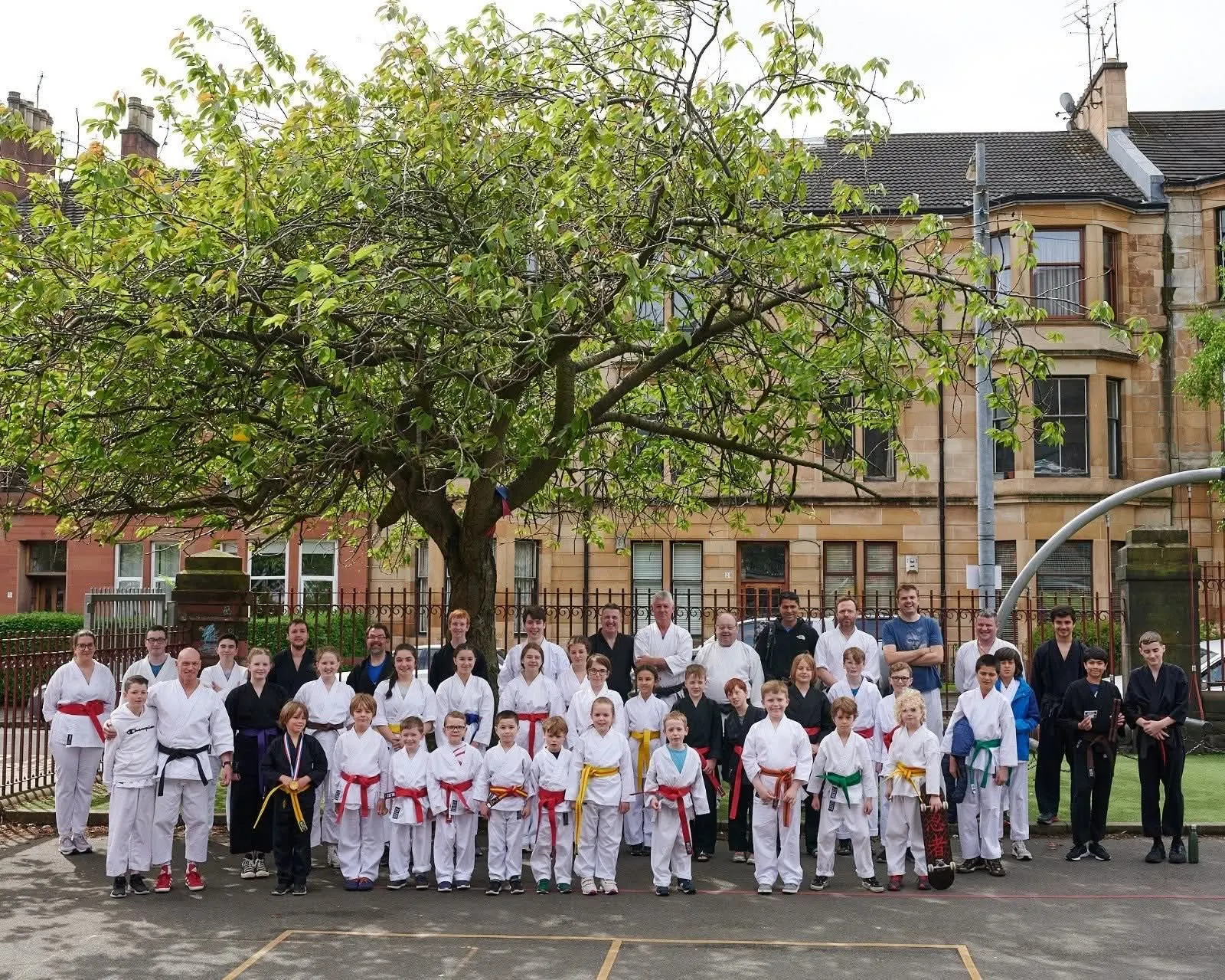 Juniors and seniors of the association lined up for a group photo outside a school