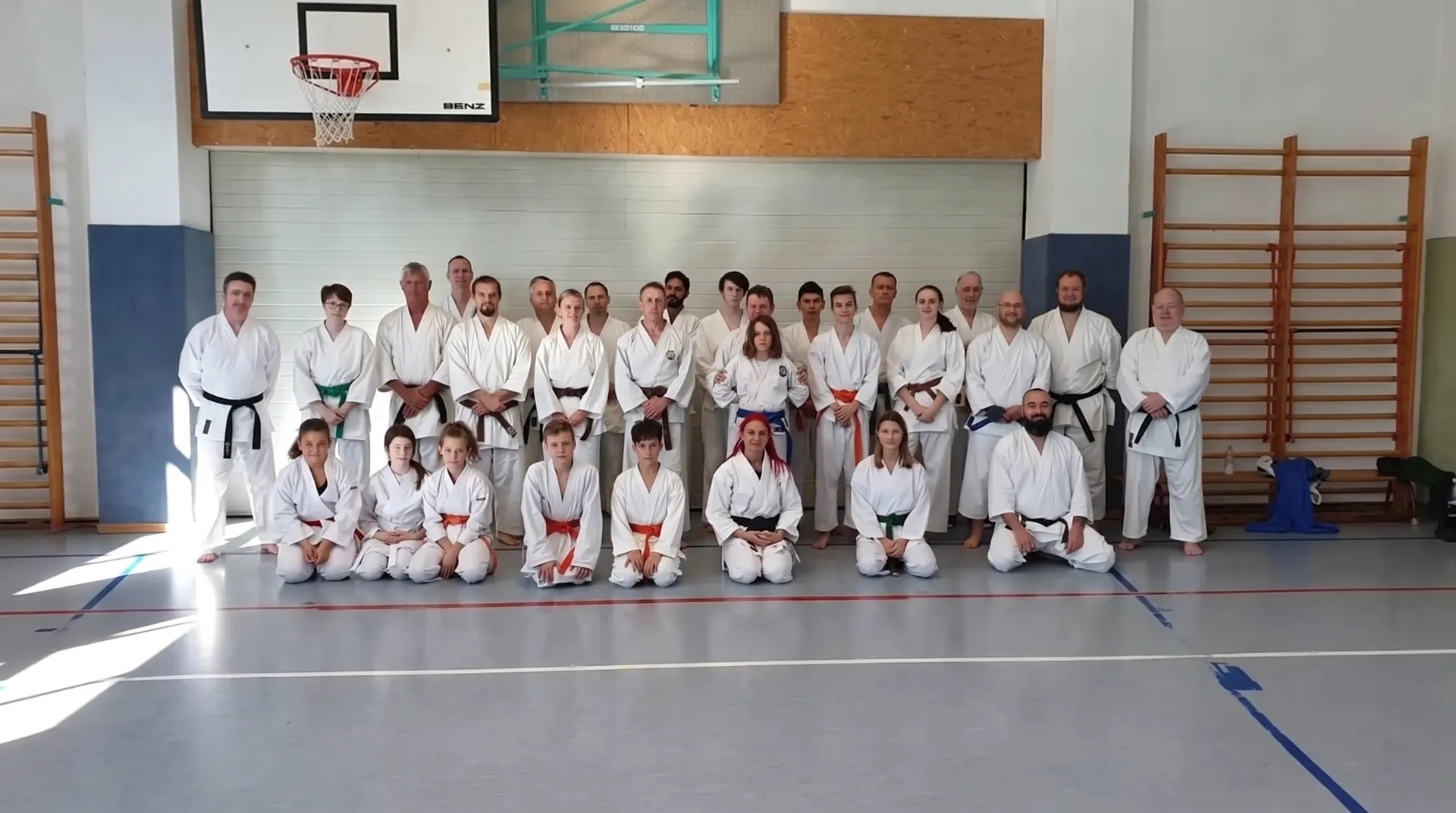 Juniors and seniors gathered for a group photo in a sports hall