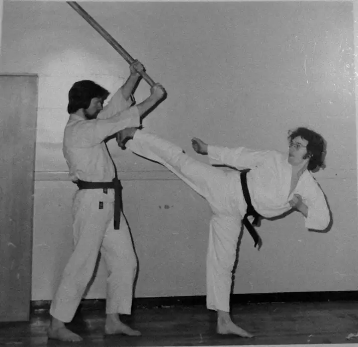 Black and white archive photo of a kick blocked by a staff