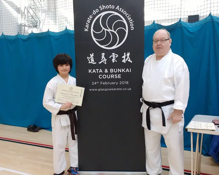An instructor with a junior member holding a certificate at a kata and bunkai course