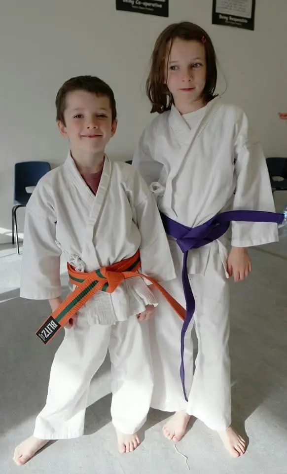 Three juniors wearing orange, purple and green belts