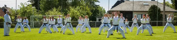 A large outdoor class in front stance on a field