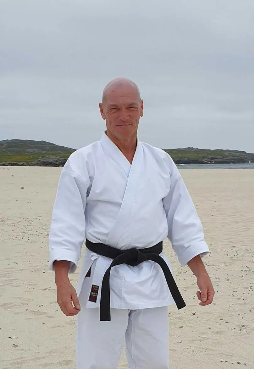 William Divens on a beach in a white gi